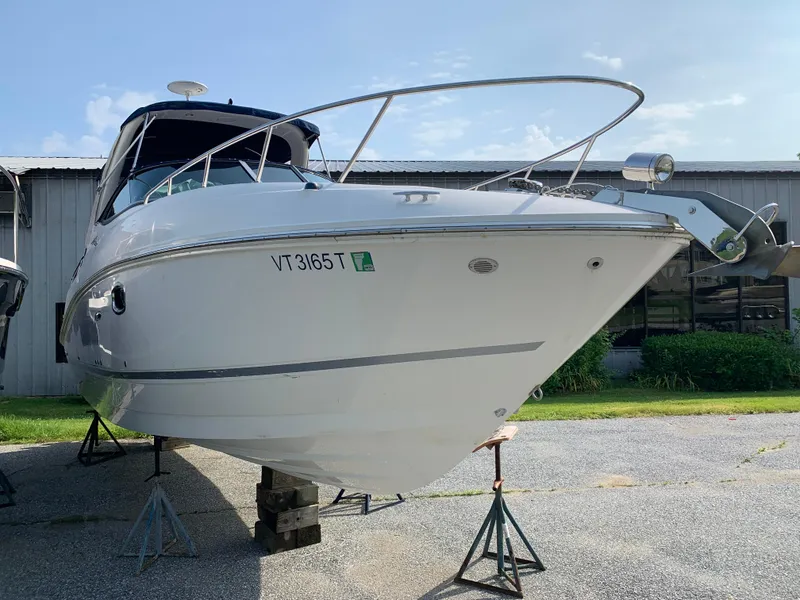 Slide: The Image of 2010 Sea Ray 260 Sundancer boat on stands, parked outdoors. - 2