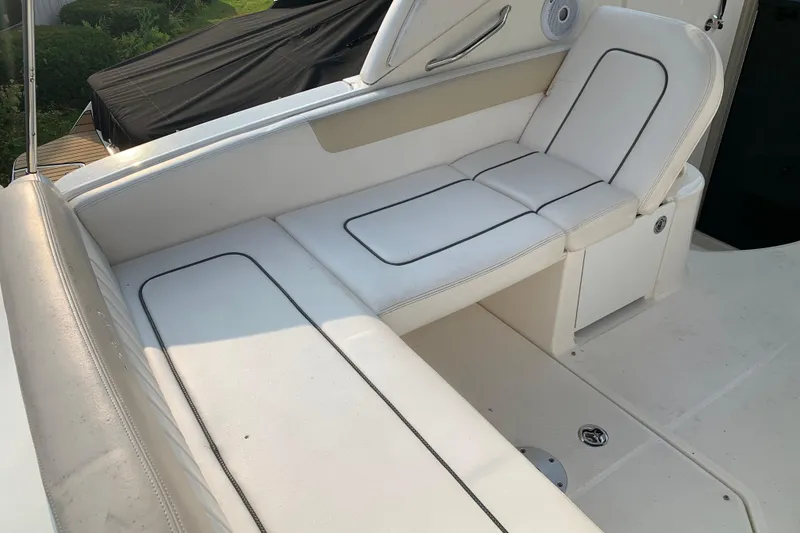 Slide: The Image of 2010 Sea Ray 260 Sundancer boat interior with white cushioned seating. - 25