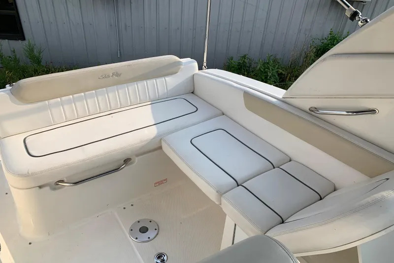 Slide: The Image of 2010 Sea Ray 260 Sundancer boat interior with white cushioned seating. - 27