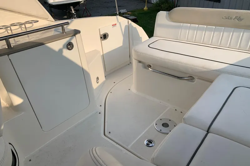 Slide: The Image of Interior of 2010 Sea Ray 260 Sundancer boat with white seating and storage compartments. - 29