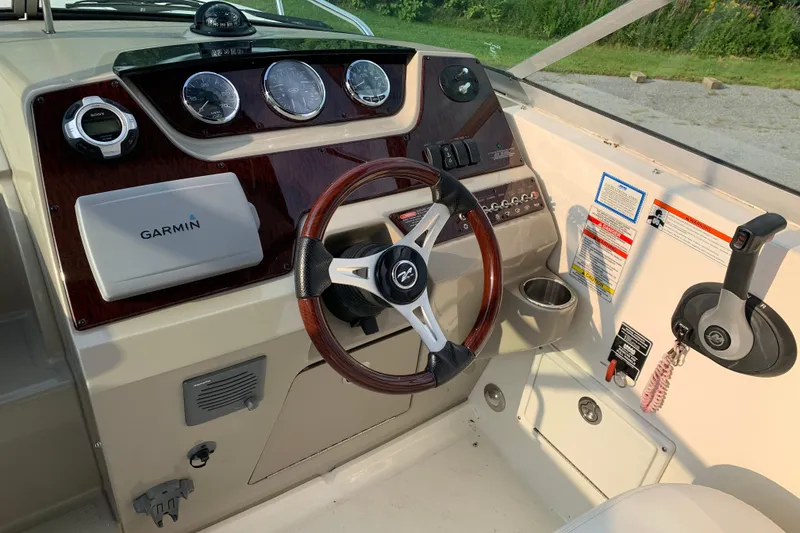 Slide: The Image of 2010 Sea Ray 260 Sundancer helm with Garmin navigation and wood-accented steering wheel. - 32