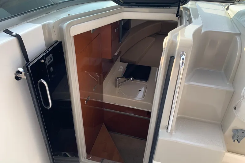 Slide: The Image of 2010 Sea Ray 260 Sundancer cabin entrance with compact kitchenette and steps. - 40