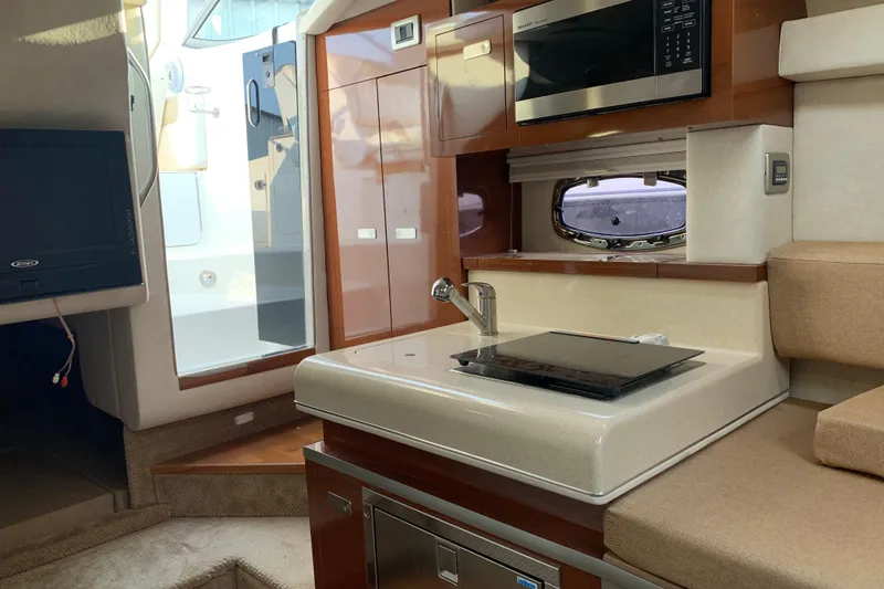 Slide: The Image of Interior of 2010 Sea Ray 260 Sundancer with kitchenette, microwave, and seating area. - 45