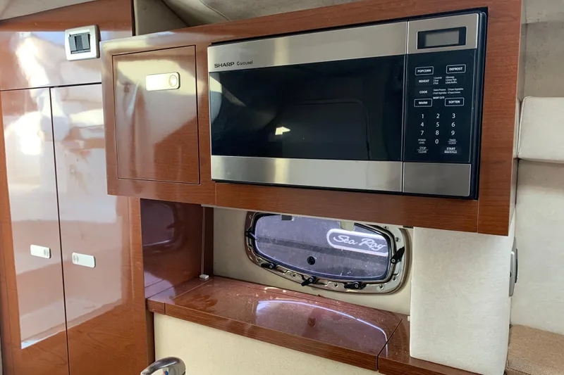 Slide: The Image of Interior of 2010 Sea Ray 260 Sundancer with microwave and wooden cabinetry. - 47