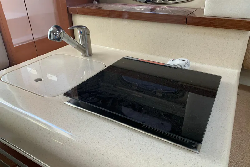 Slide: The Image of 2010 Sea Ray 260 Sundancer kitchen area with sink and stovetop. - 48