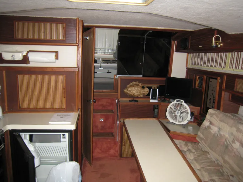Slide: The Image of 1986 Sea Ray 340 Express Cruiser interior with kitchenette, seating, and storage cabinets. - 13