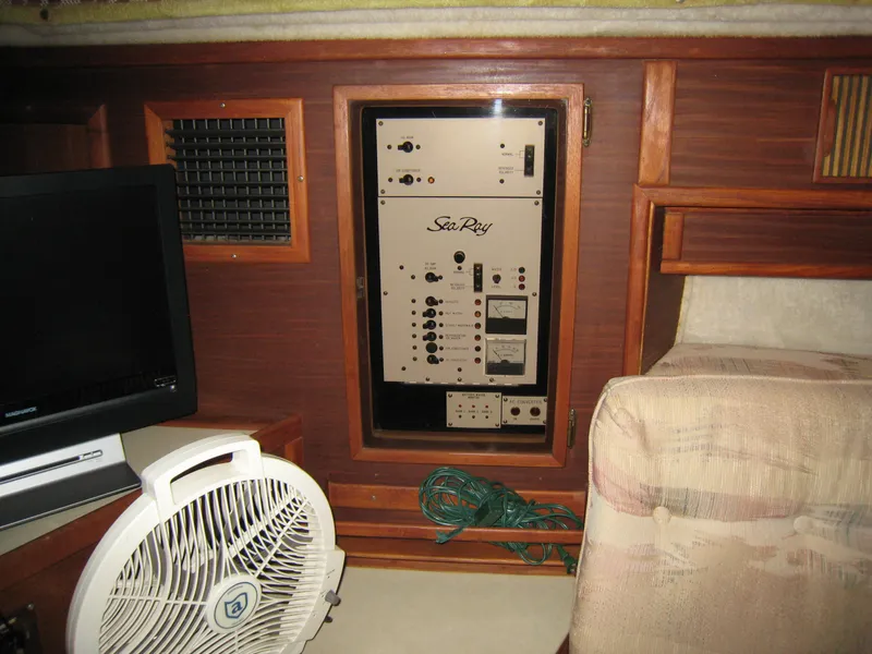 Slide: The Image of 1986 Sea Ray 340 Express Cruiser interior with control panel, fan, and wooden cabinetry. - 14