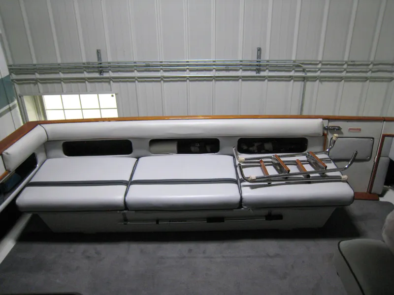 Slide: The Image of 1986 Sea Ray 340 Express Cruiser interior with white seating and storage compartments. - 7