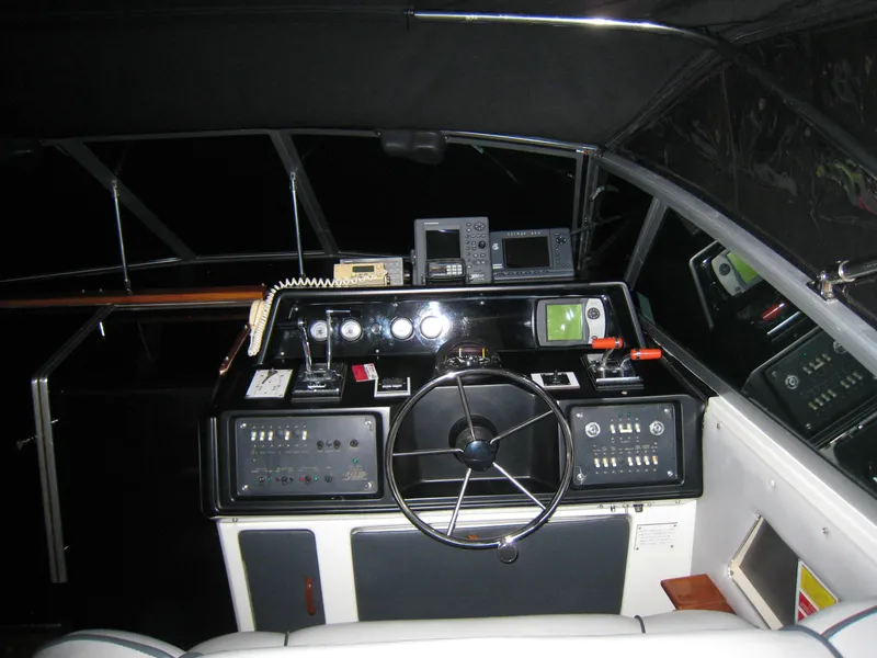Slide: The Image of 1986 Sea Ray 340 Express Cruiser helm with navigation instruments and steering wheel. - 8