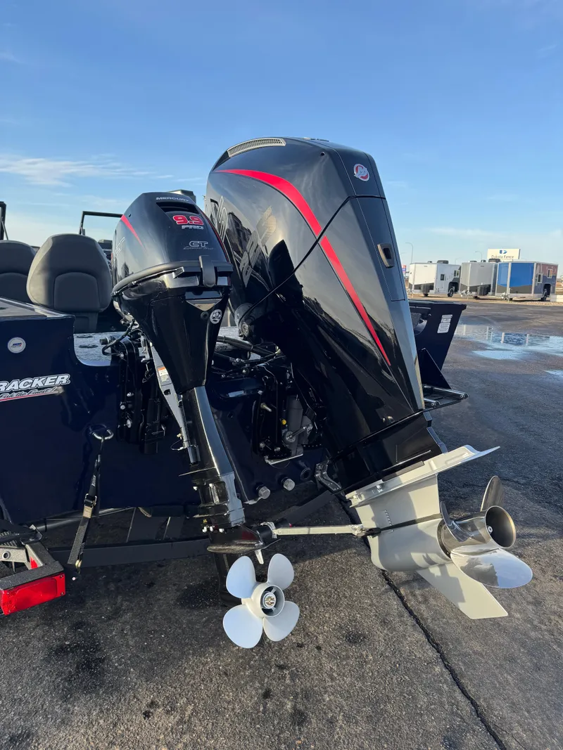 Slide: The Image of 2024 Tracker Targa V-19 WT boat with dual outboard motors, parked on a sunny day. - 4