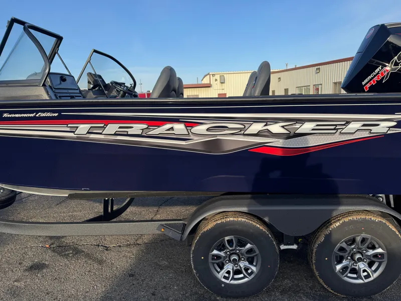 Slide: The Image of 2024 Tracker Targa V-19 WT boat on trailer, side view, blue with red accents. - 5
