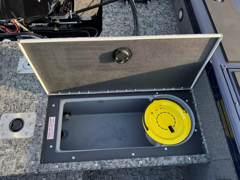 Slide: The Image of 2024 Tracker Targa V-19 WT boat storage compartment with yellow lid, open and empty. - 8