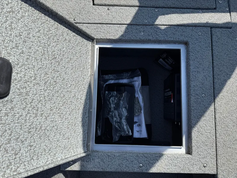 Slide: The Image of Storage compartment in 2017 Lund 1650 Rebel XS SS boat, open with items inside. - 11