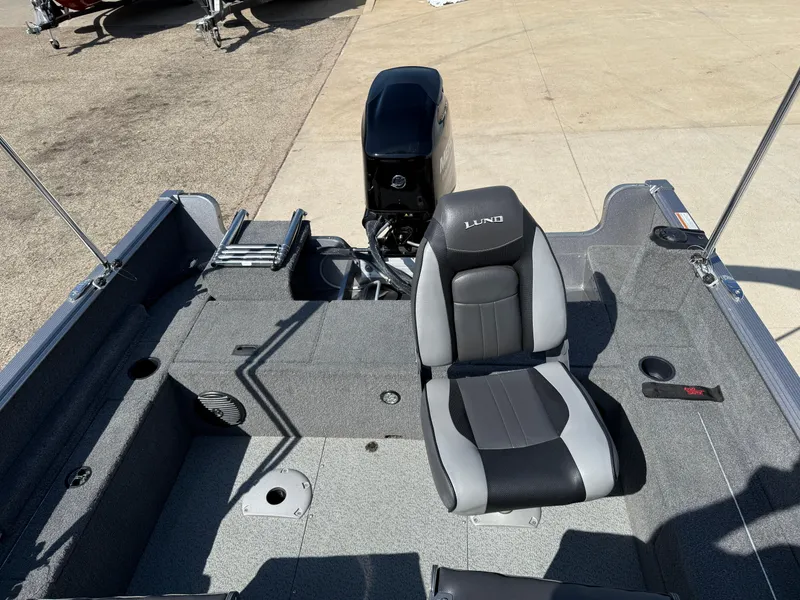 Slide: The Image of 2017 Lund 1650 Rebel XS SS boat interior with seating and motor, parked on concrete. - 25