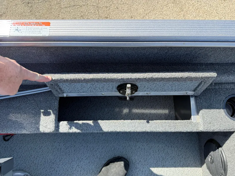 Slide: The Image of 2017 Lund 1650 Rebel XS SS boat storage compartment with latch, open and accessible. - 26