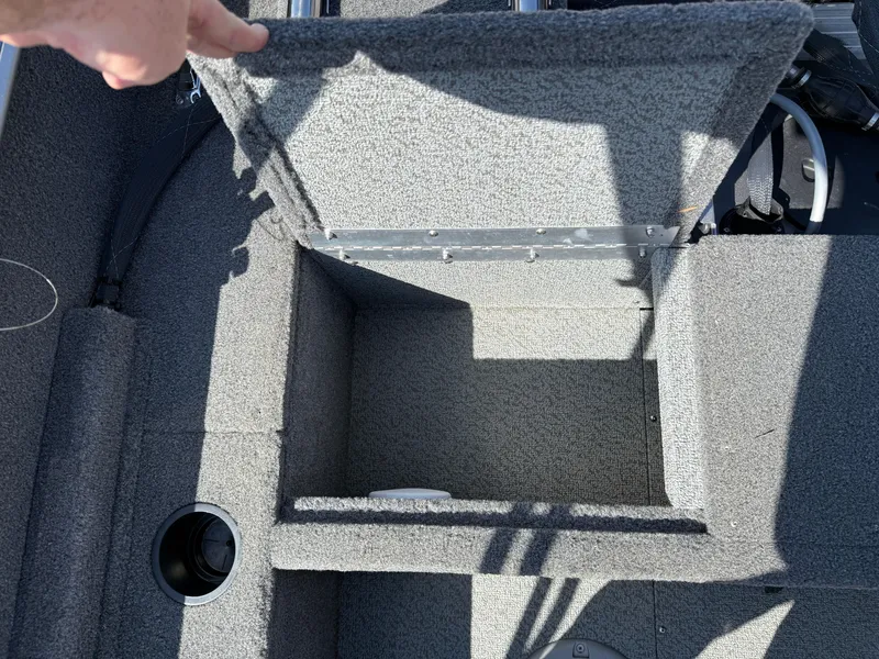 Slide: The Image of 2017 Lund 1650 Rebel XS SS boat storage compartment open, showing interior space. - 27