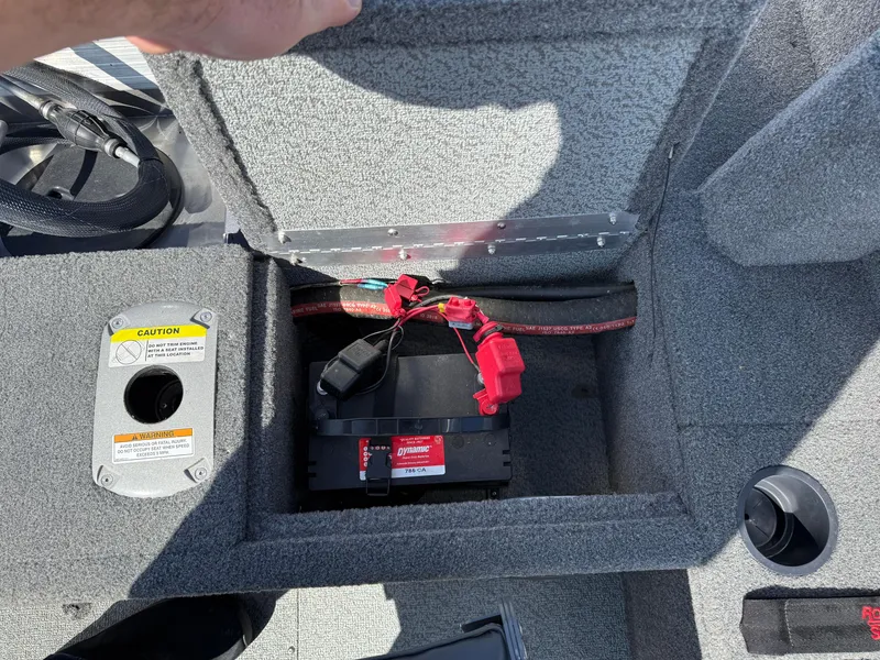 Slide: The Image of 2017 Lund 1650 Rebel XS SS boat battery compartment with wiring and caution label. - 28