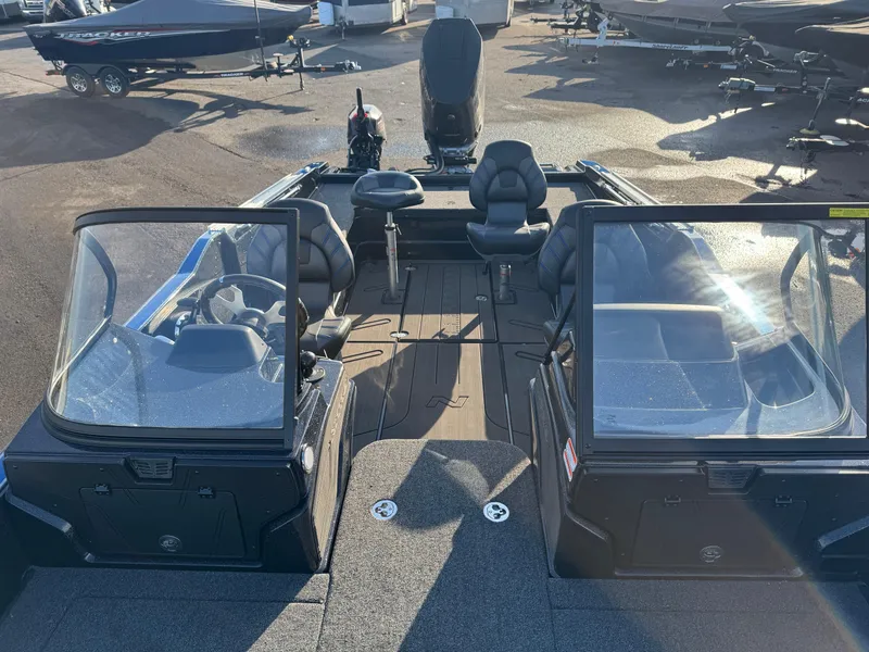 Slide: The Image of 2024 Nitro ZV21 Pro boat interior with seating and windshield, parked outdoors. - 15