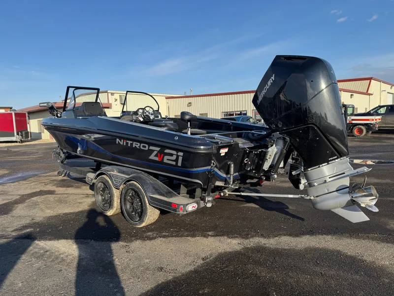 Slide: The Image of 2024 Nitro ZV21 Pro boat with powerful outboard motor, parked outdoors. - 2