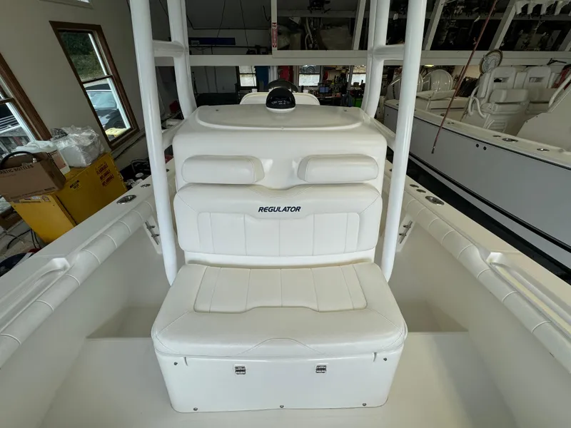 Slide: The Image of 2012 Regulator 24 Forward Seating boat interior with white cushioned seats. - 10