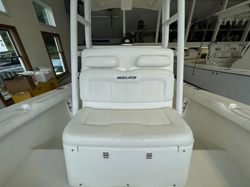 Slide: The Image of 2012 Regulator 24 Forward Seating boat interior with white cushioned seating. - 11