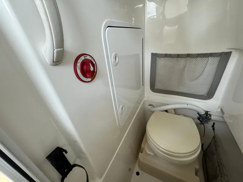 Slide: The Image of 2012 Regulator 24 Forward Seating boat interior with toilet and storage compartment. - 16