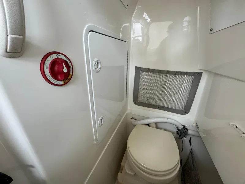 Slide: The Image of 2012 Regulator 24 Forward Seating boat interior with toilet and storage compartment. - 17