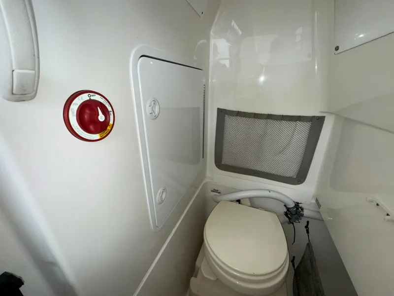 Slide: The Image of 2012 Regulator 24 Forward Seating boat interior with toilet and storage compartment. - 18