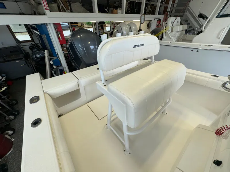 Slide: The Image of 2012 Regulator 24 Forward Seating boat interior with white cushioned seating. - 19