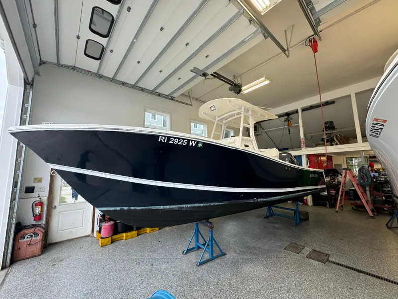 Slide: The Image of 2012 Regulator 24 Forward Seating boat in garage, elevated on stands. - 2