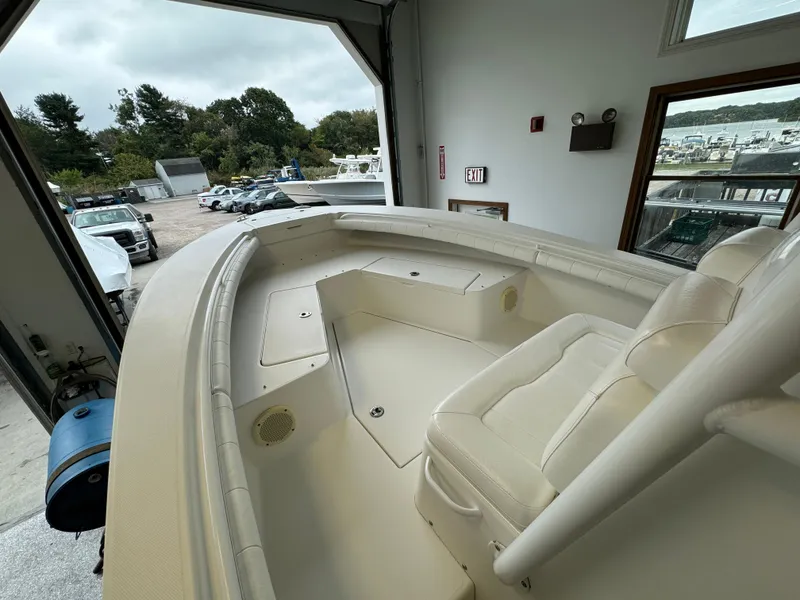 Slide: The Image of 2012 Regulator 24 Forward Seating boat interior with white upholstery in a garage setting. - 4