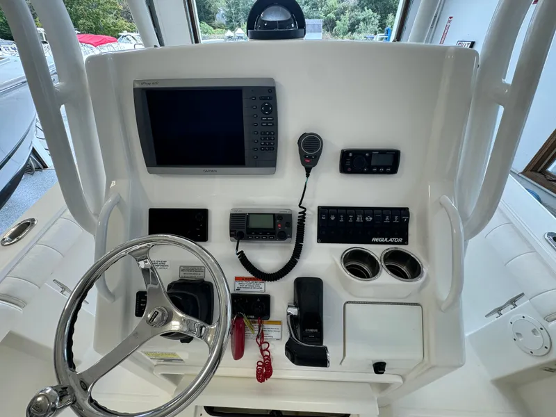 Slide: The Image of 2012 Regulator 24 Forward Seating boat dashboard with steering wheel and navigation controls. - 8