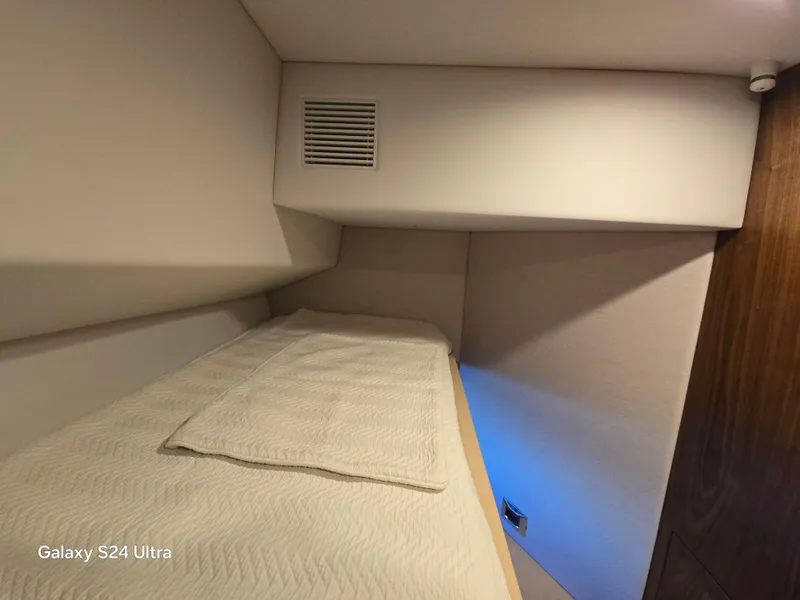 Slide: The Image of Interior cabin of 2022 Riviera 54 Enclosed Flybridge yacht, featuring a cozy bed. - 22