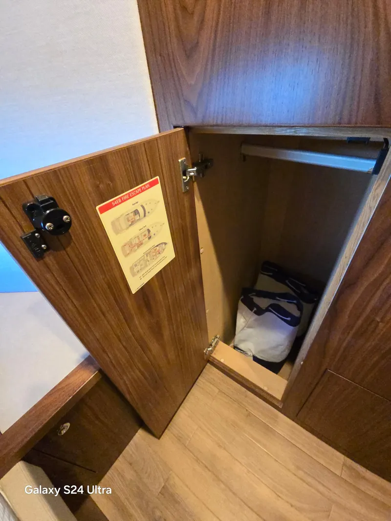 Slide: The Image of Open wooden cabinet on Riviera 54 Enclosed Flybridge 2022 yacht interior. - 23