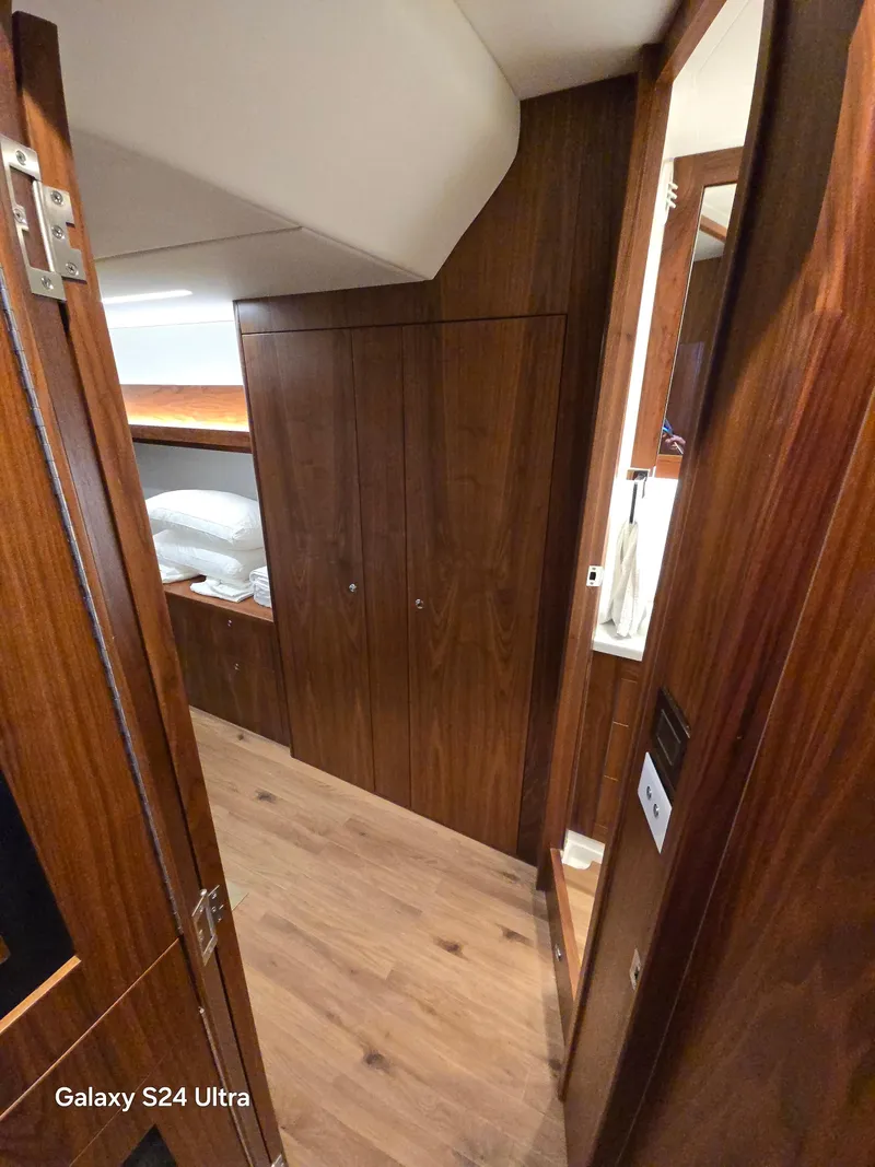 Slide: The Image of Interior of 2022 Riviera 54 Enclosed Flybridge with wooden cabinetry and flooring. - 26