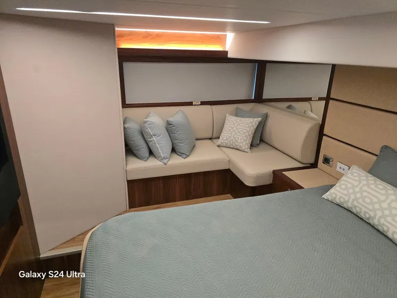 Slide: The Image of Luxurious interior of 2022 Riviera 54 Enclosed Flybridge with elegant seating and bedding. - 27