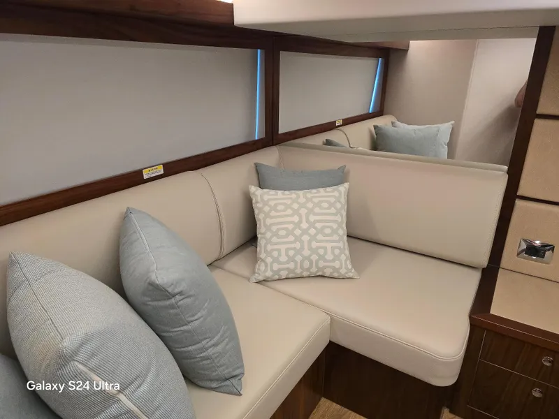 Slide: The Image of Luxurious interior of 2022 Riviera 54 Enclosed Flybridge with elegant cushions and seating. - 29