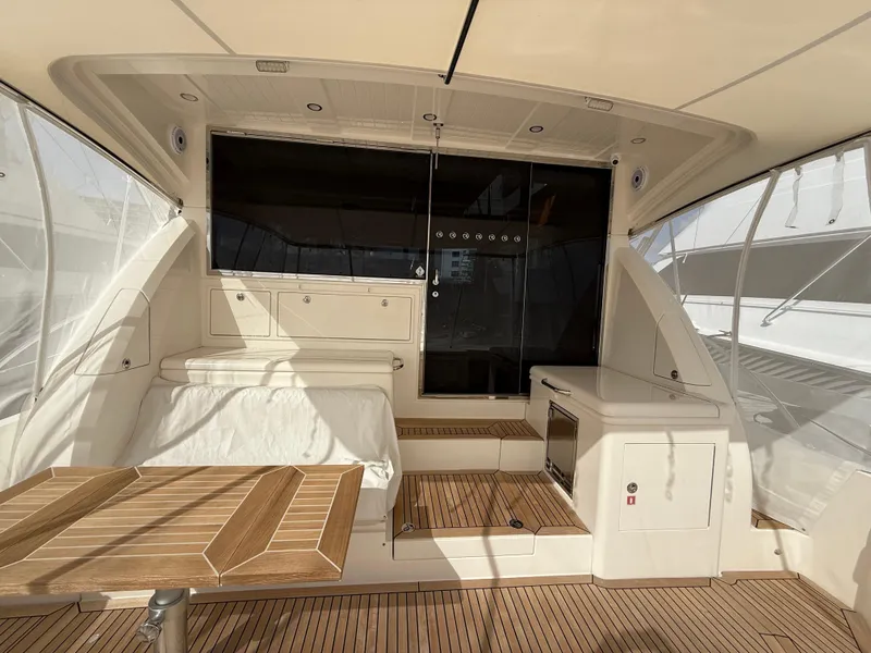 Slide: The Image of 2022 Riviera 54 Enclosed Flybridge interior with teak flooring and modern seating area. - 3