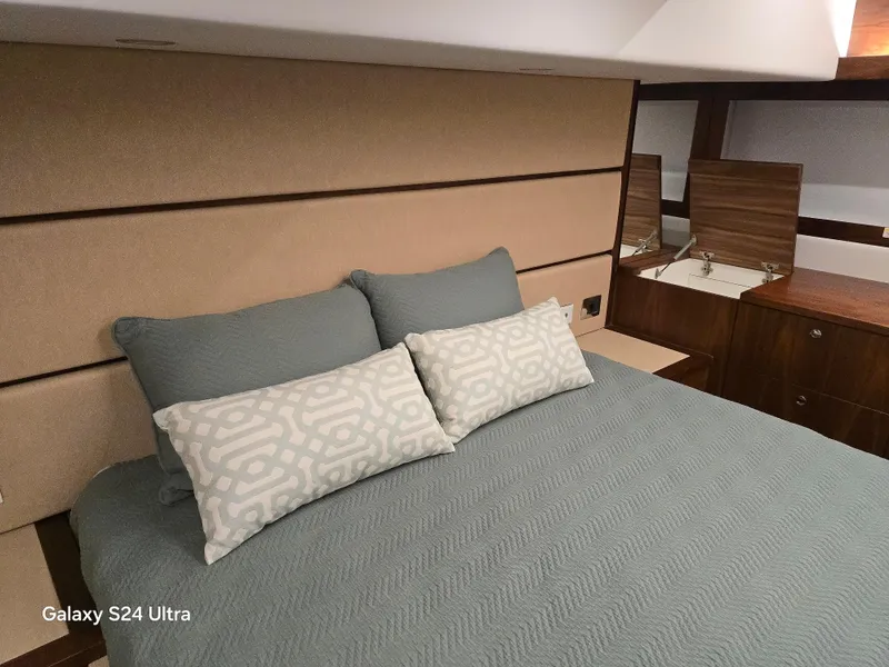 Slide: The Image of Luxurious bedroom interior of 2022 Riviera 54 Enclosed Flybridge yacht with elegant bedding. - 30