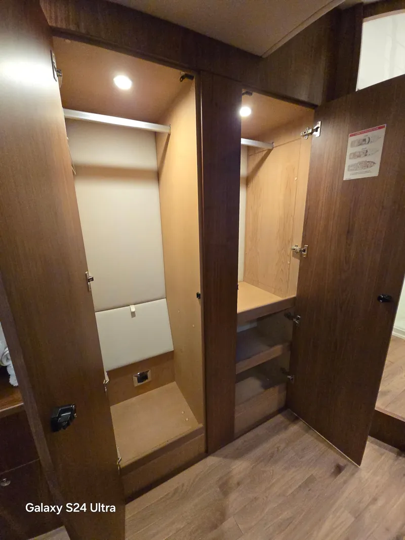 Slide: The Image of Wooden closet interior on a 2022 Riviera 54 Enclosed Flybridge yacht. - 35