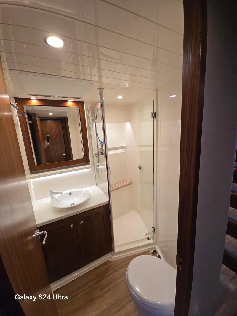 Slide: The Image of Luxurious bathroom in 2022 Riviera 54 Enclosed Flybridge yacht, featuring modern fixtures and elegant design. - 4