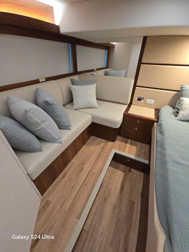 Slide: The Image of 2022 Riviera 54 Enclosed Flybridge interior with modern seating and elegant wood flooring. - 41