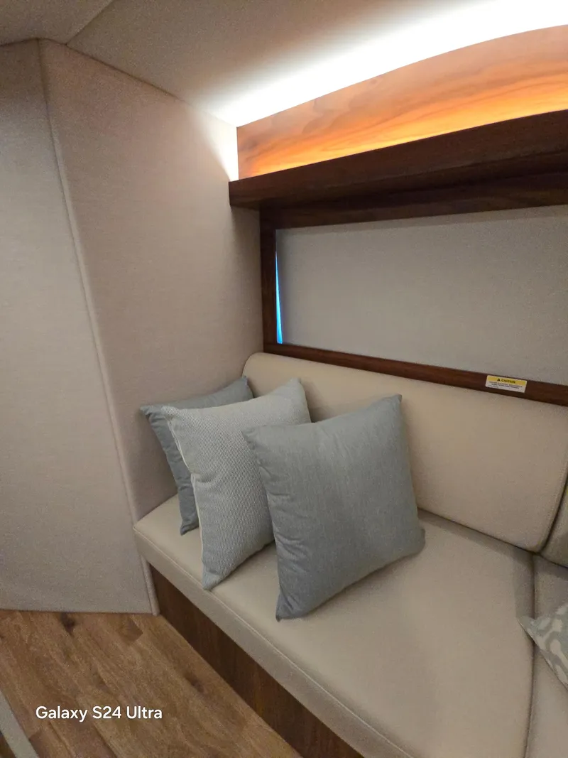 Slide: The Image of Interior of 2022 Riviera 54 Enclosed Flybridge with cushioned seating and pillows. - 45