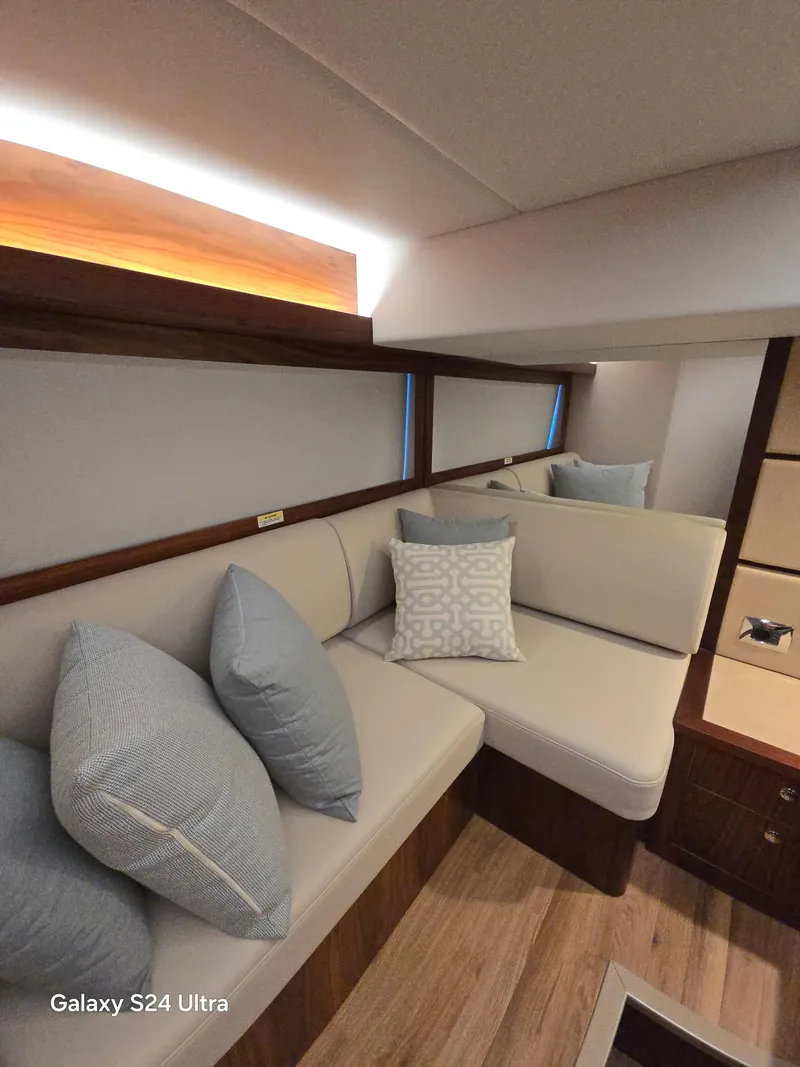 Slide: The Image of Interior of 2022 Riviera 54 Enclosed Flybridge with cozy seating and decorative pillows. - 46