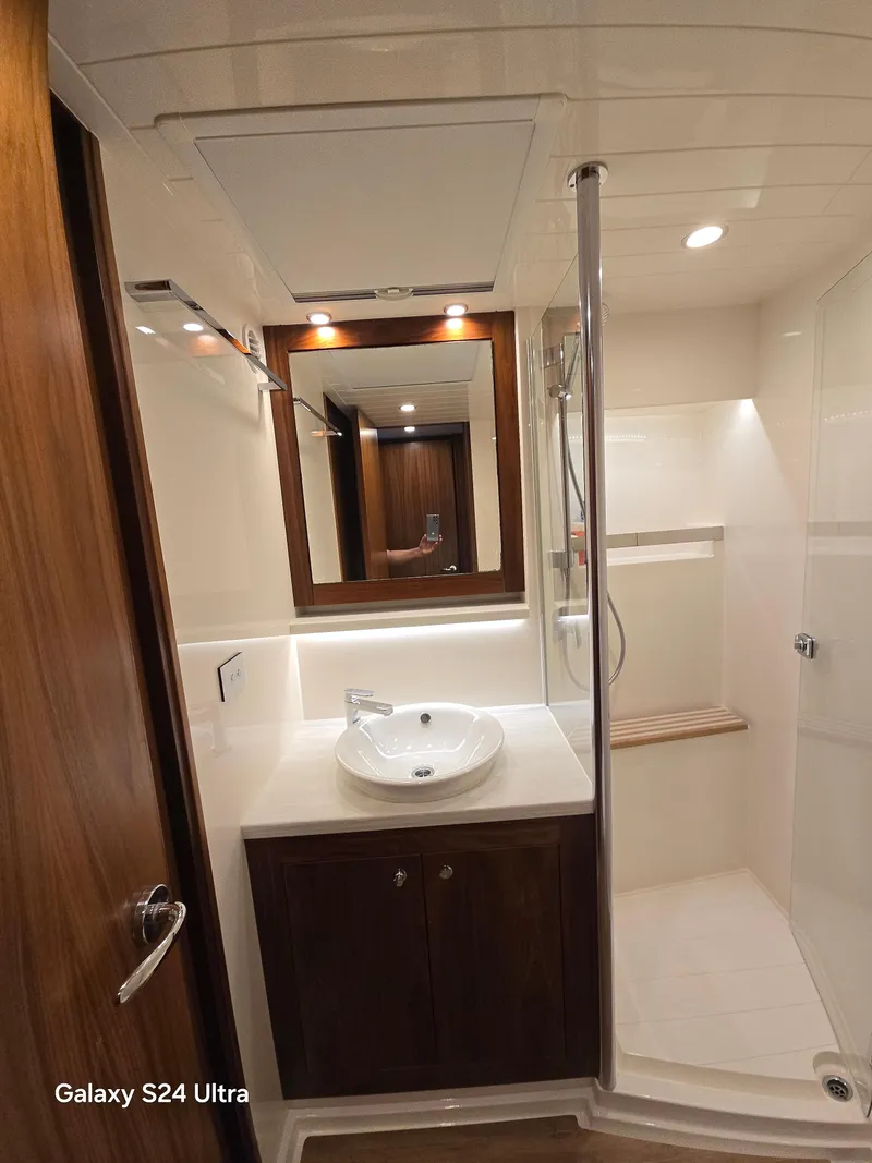 Slide: The Image of Luxurious bathroom in 2022 Riviera 54 Enclosed Flybridge yacht with modern fixtures and wood accents. - 6