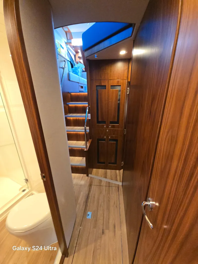 Slide: The Image of Interior of 2022 Riviera 54 Enclosed Flybridge with wooden finishes and staircase. - 9