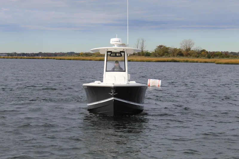 Slide: The Image of 2021 Regulator 23 FS boat on calm water, front view with distant shoreline. - 3