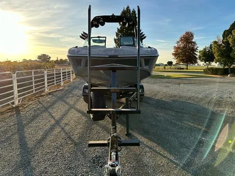Slide: The Image of 2025 MB B52 25 Alpha boat on trailer at sunset, parked on gravel road. - 3
