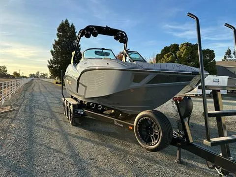 Slide: The Image of 2025 MB B52 25 Alpha boat on trailer, parked on a gravel road. - 4