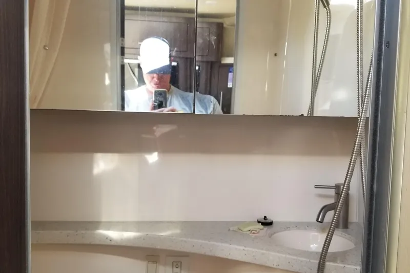 Slide: The Image of Interior of 2018 Regal 28 Express boat bathroom with mirror and sink. - 12